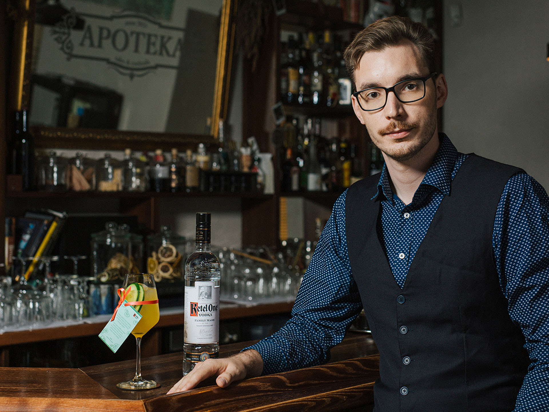Karolis Jauniškis standing in a bar with Ketel One Vodka and a cocktail