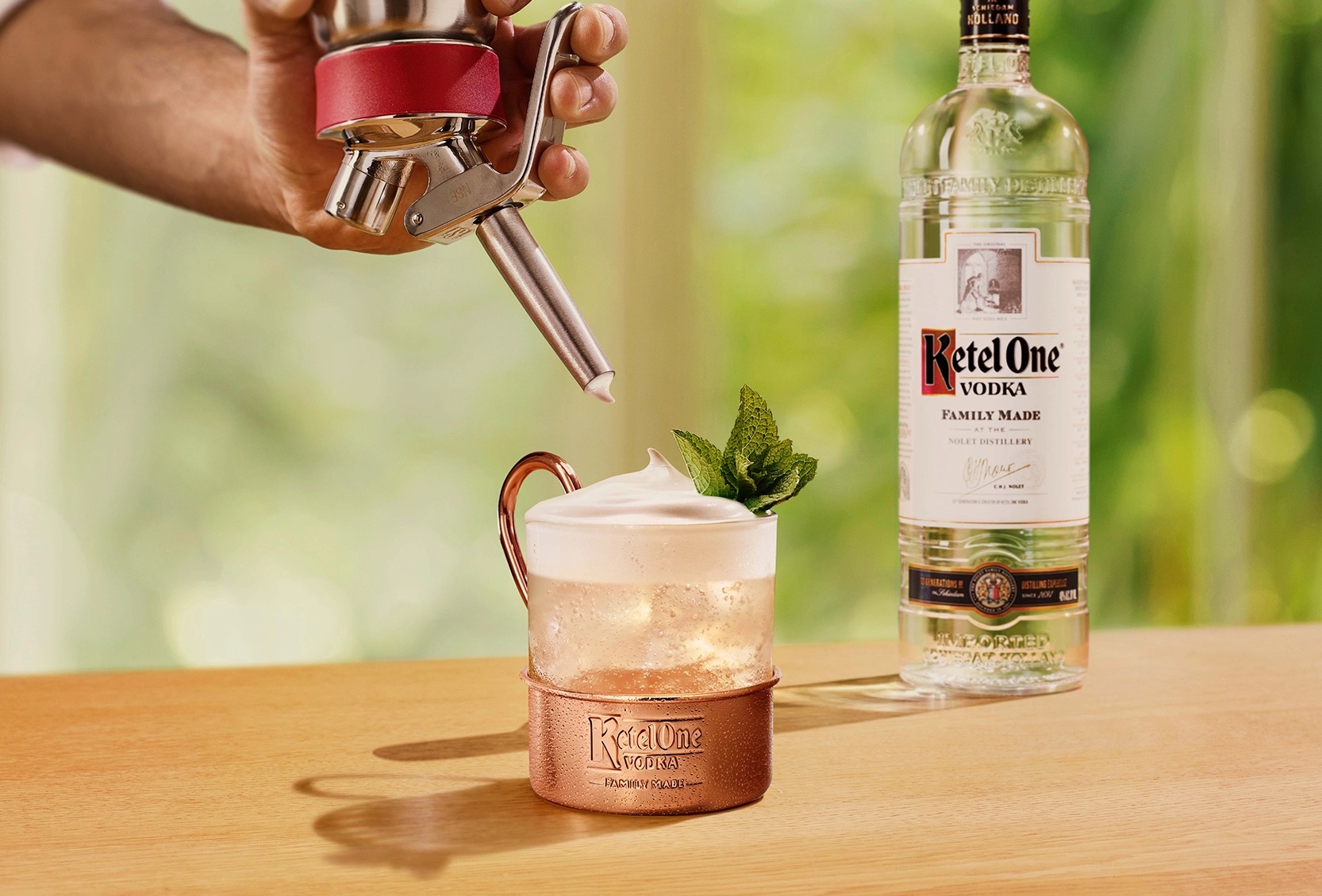 Ketel One Brazil Mule in Glass Mug with hand adding cream