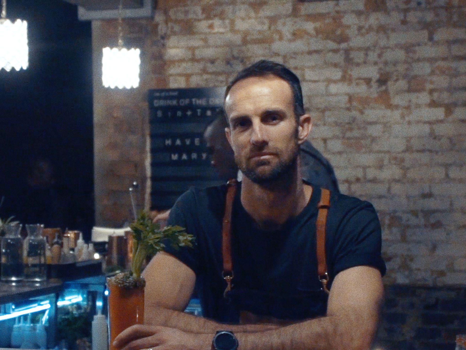 Travis Kuhn en un bar sosteniendo un cóctel