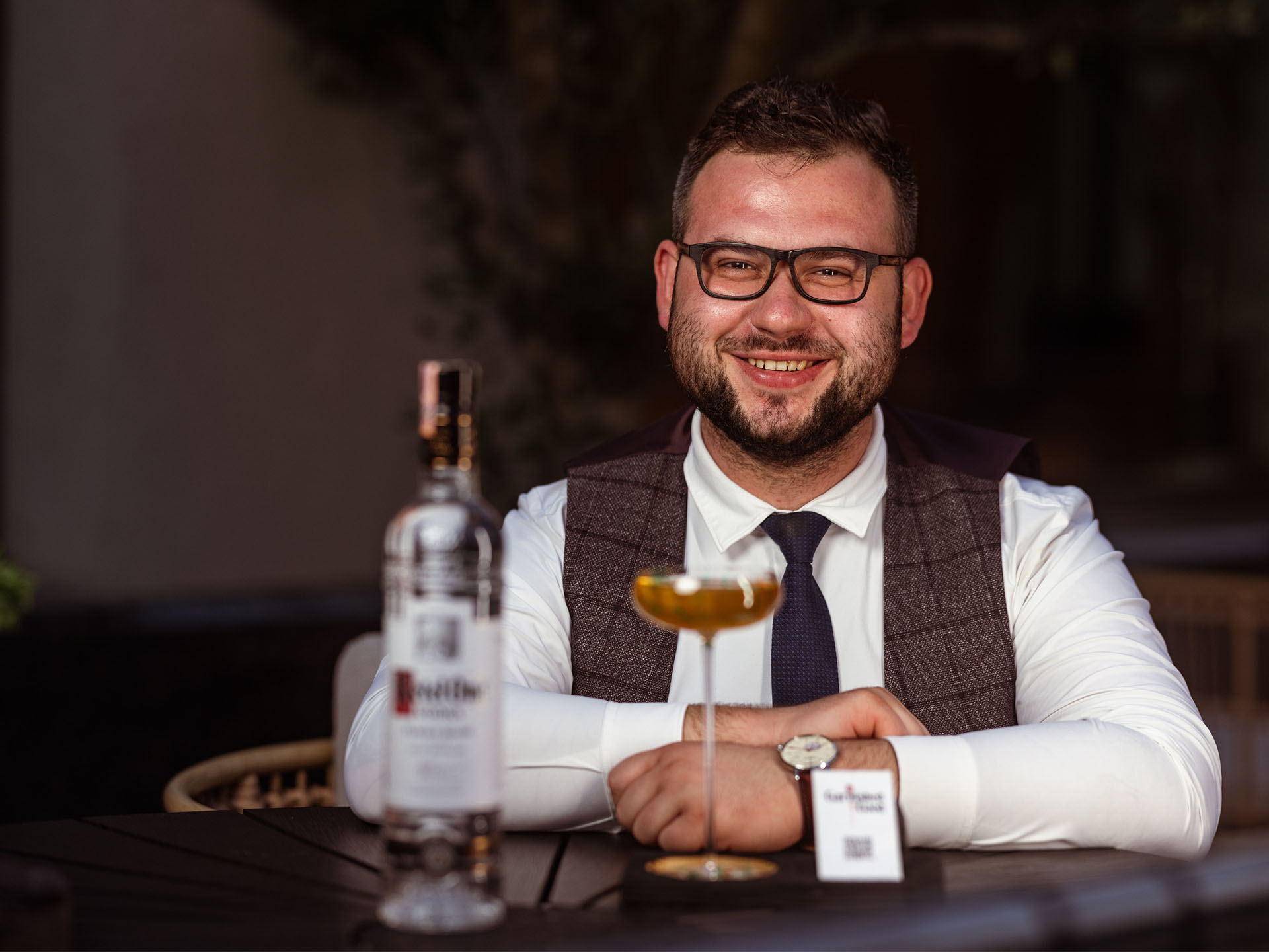 Martin Zupina smiling in a bar with Ketel One Vodka and a cocktail