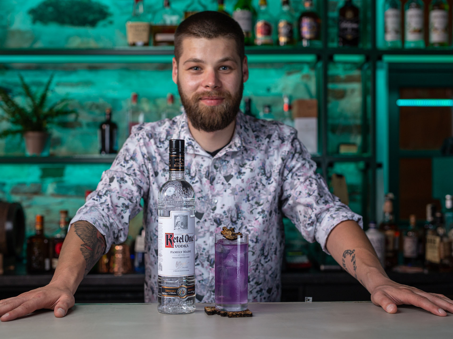 Mihai Pop standing behind a bar with Ketel One Vodka and a cocktail