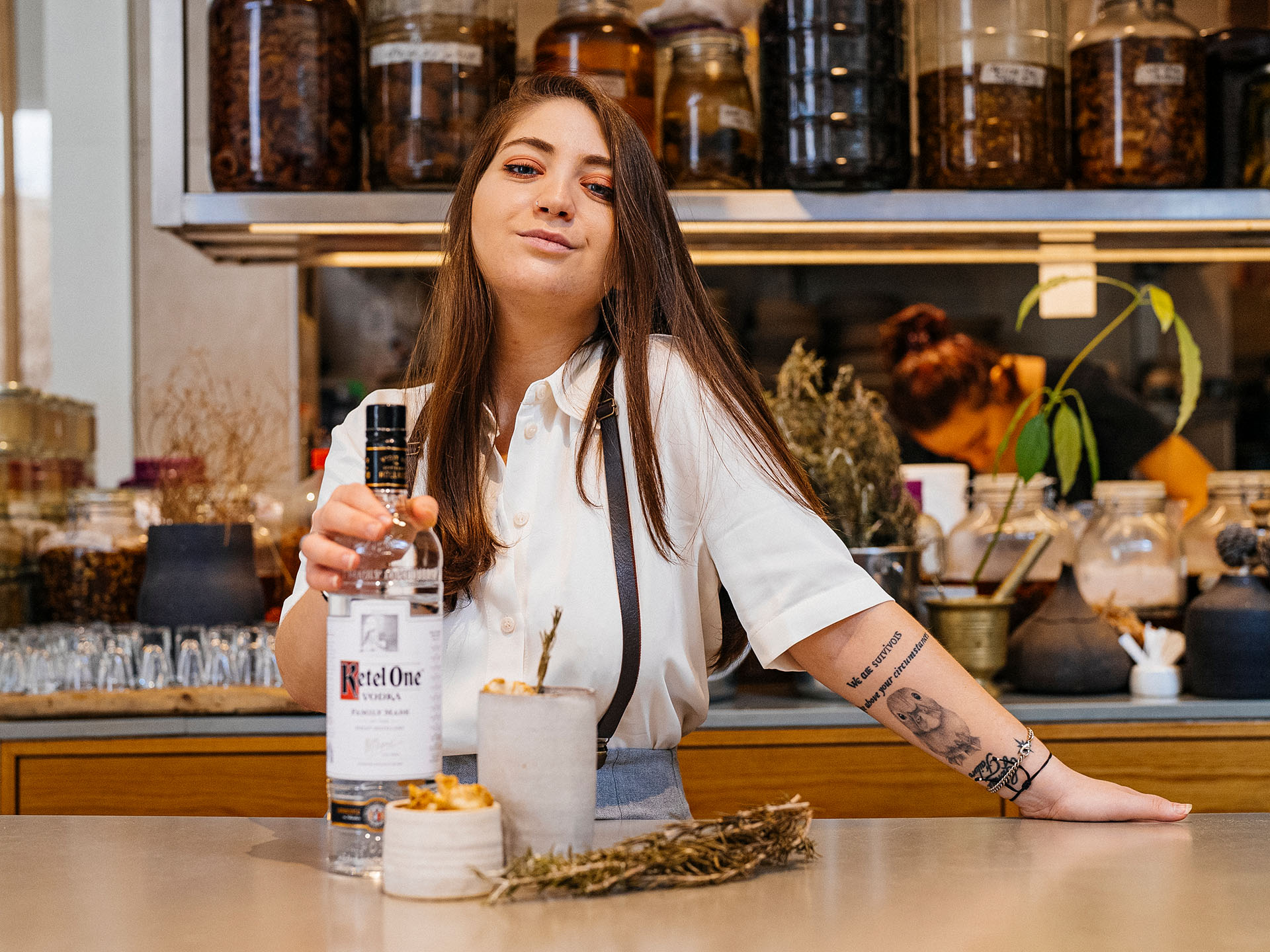 Corrie Levis standing in a bar with Ketel One Vodka and a cocktail