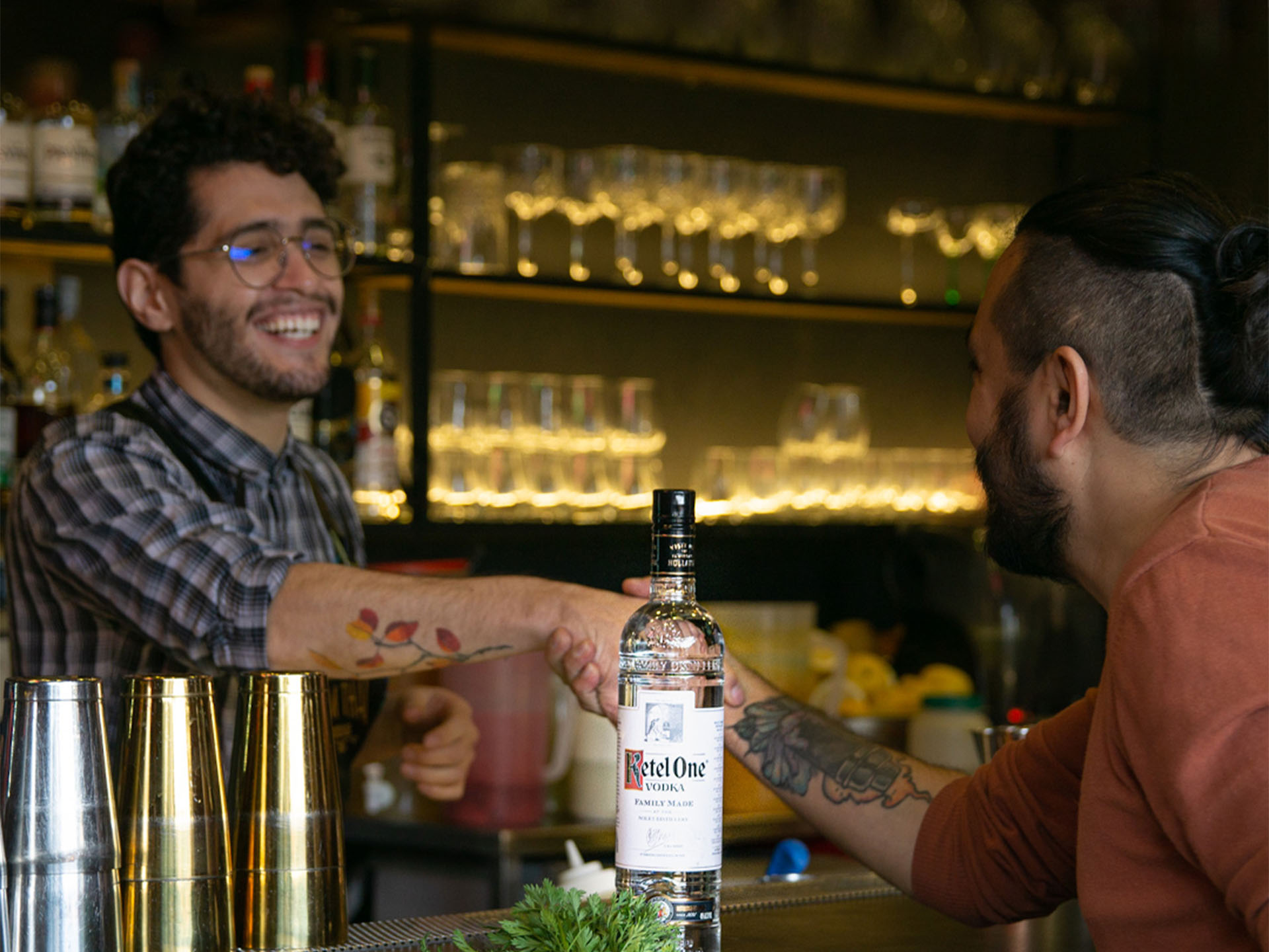 Camilo Solano shaking a man's hand in a bar with Ketel One Vodka