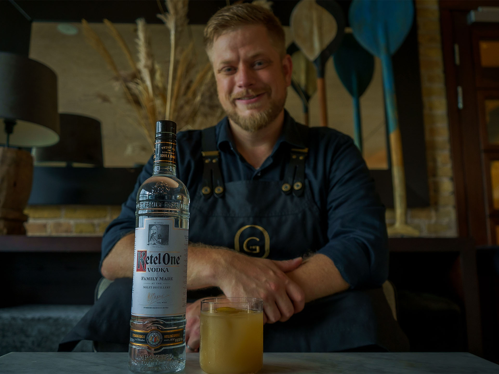 Daniel Seehuusen sitting with Ketel One Vodka and a cocktail