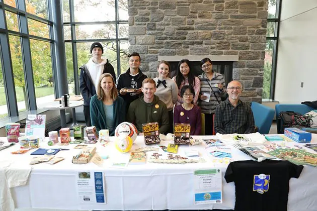 Photo of a group of people behind a table full of fair trade items