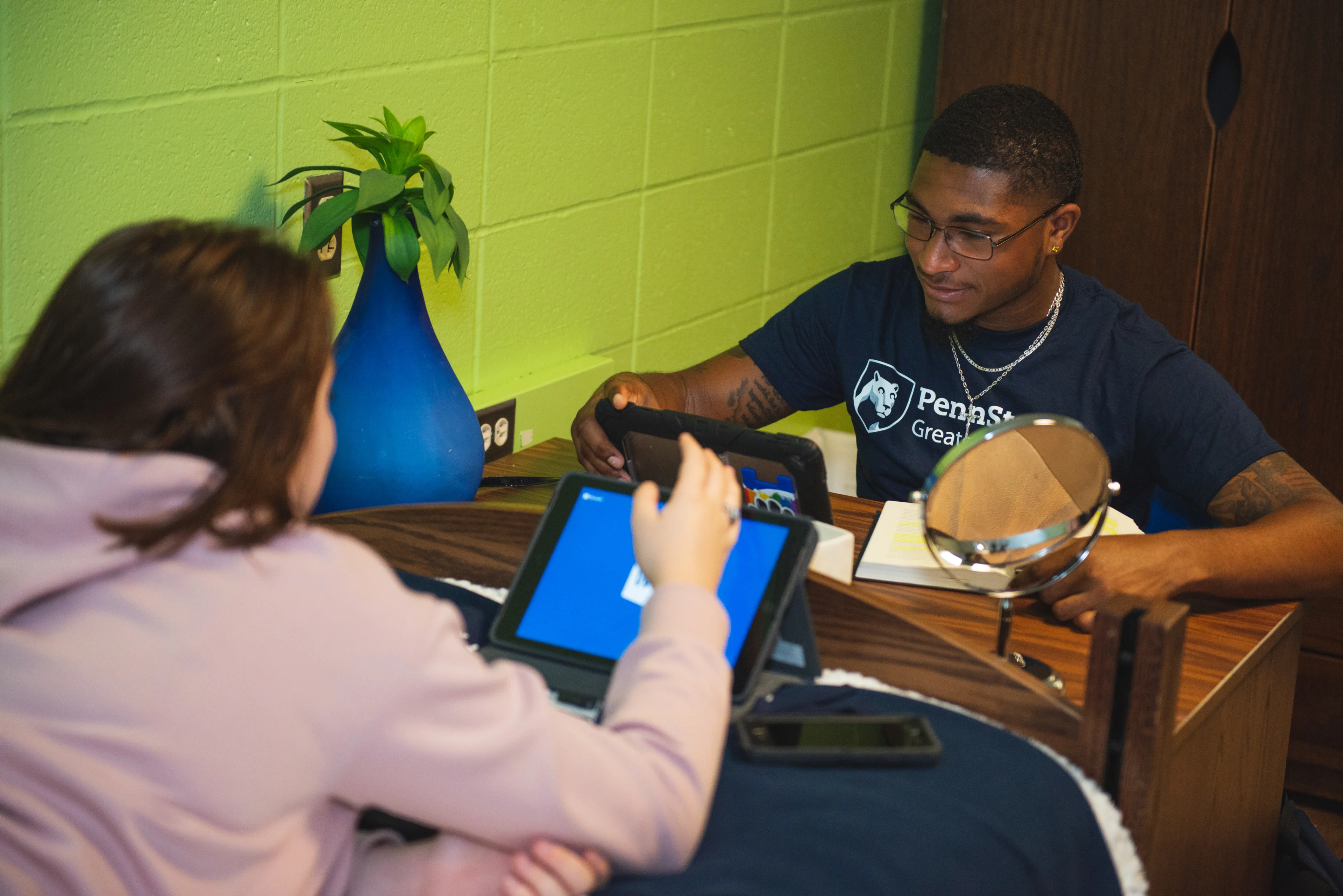 Students at desk working on tablets.