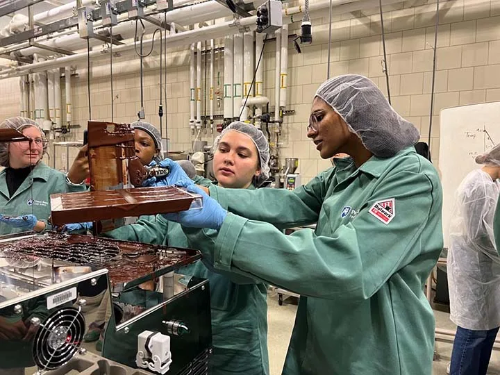 Researchers holding equipment in a lab. 