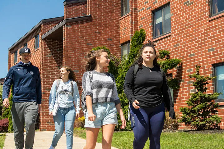 Photo of students walking outside of a residence hall