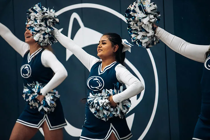 Photo of cheerleaders performing with pom poms at an event