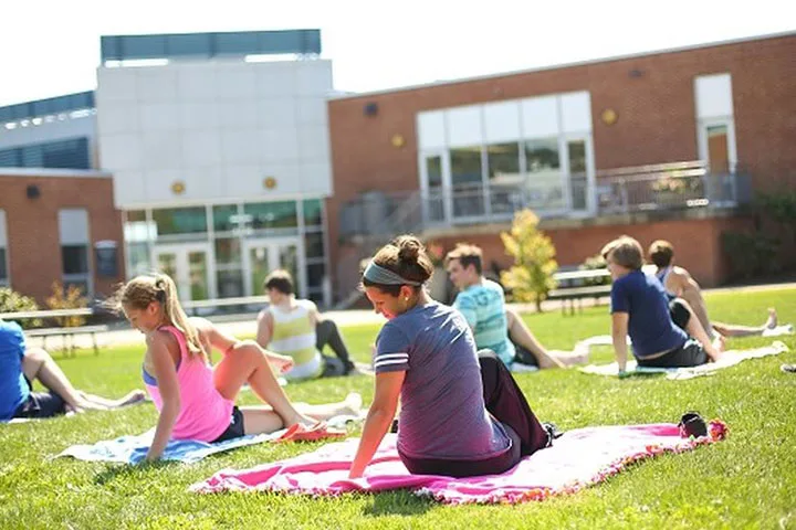 Photo of students doing yoga on a campus lawn