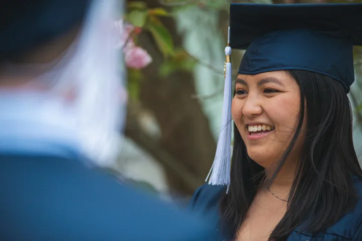 Student in graduation cap laughing