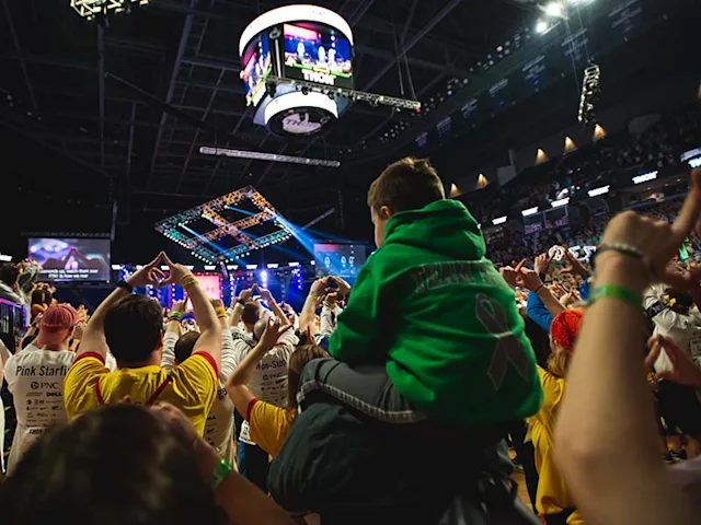 A child on his parent's shoulders in the crowd at Penn State's THON event.