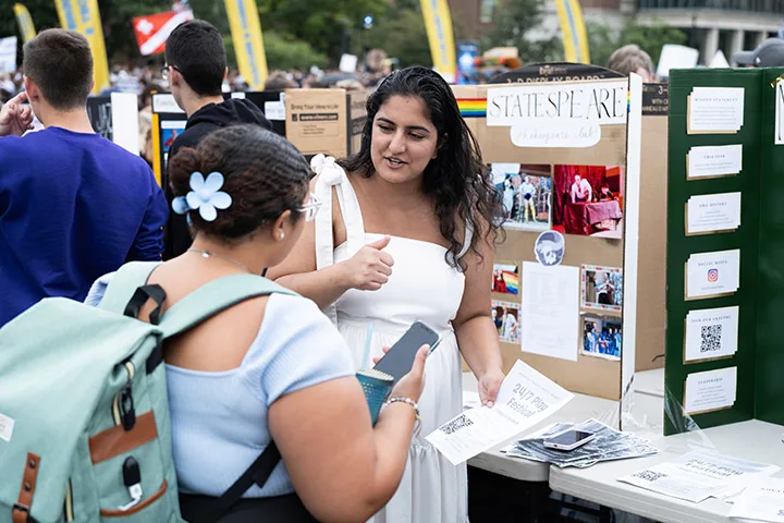 Photo of two students talking at an information table at an involvement fair