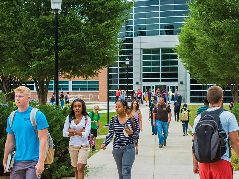 A large group of people walking on campus at Penn State Harrisburg.