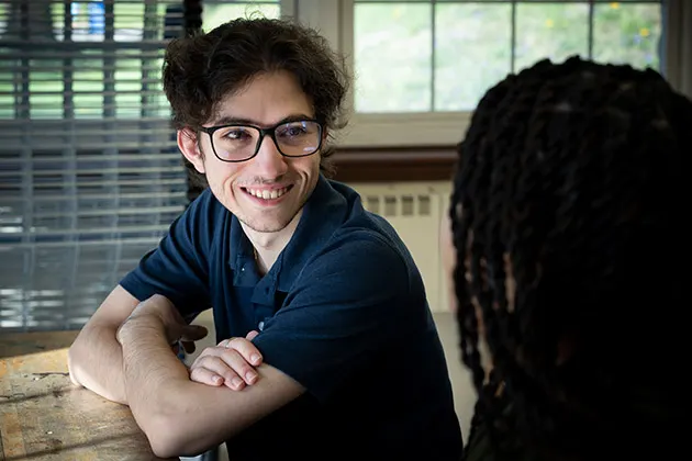 Photo of two students sitting at a table and talking