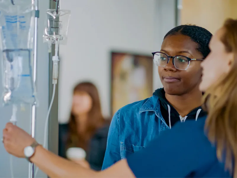 Nursing student looking at IV bag