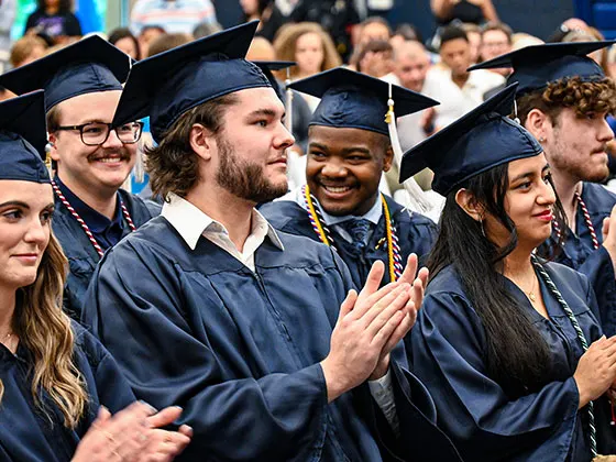Photo of students in caps and gowns at their commencement ceremony