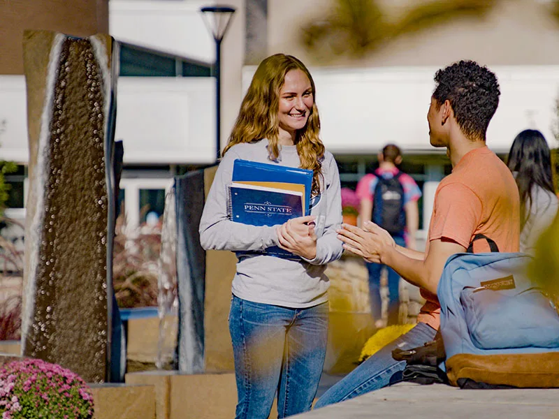 Two people talking near a foutain at Penn State Berks.