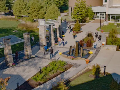 People walking around twisted sidewalks at Penn State Berks.