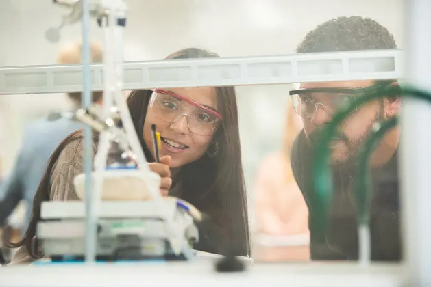 Photo of two students reviewing an experiment in a lab