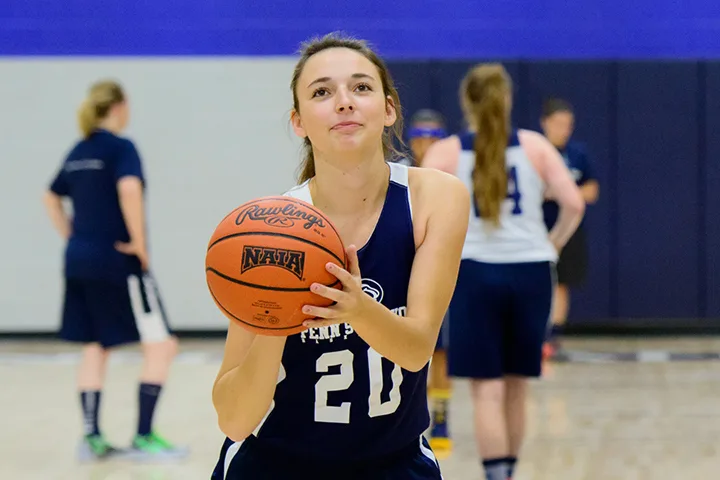 photo of a student on a basketball court shooting a basketball