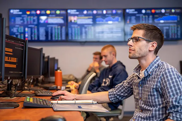 Photo of student at a terminal in the Financial Trading Lab