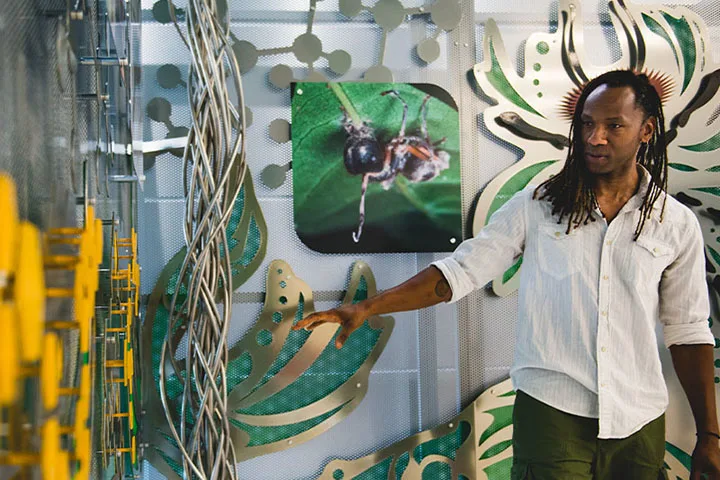 A photo of a Penn State staff member next to an art installation
