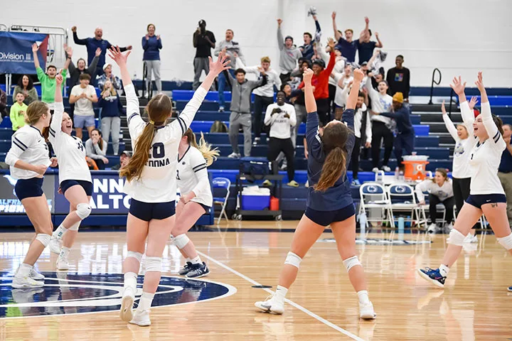 Photo of the Penn State Altoona women's volleyball team celebrating during a game