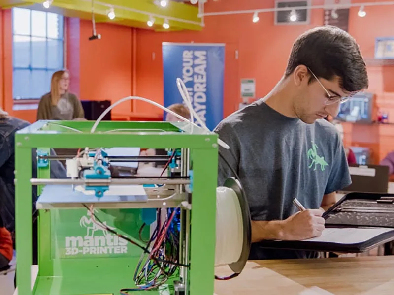 student working on a 3-D printer at Berks LaunchBox