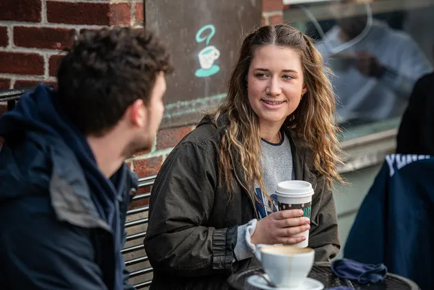 Photo of students sitting outside a coffee shop