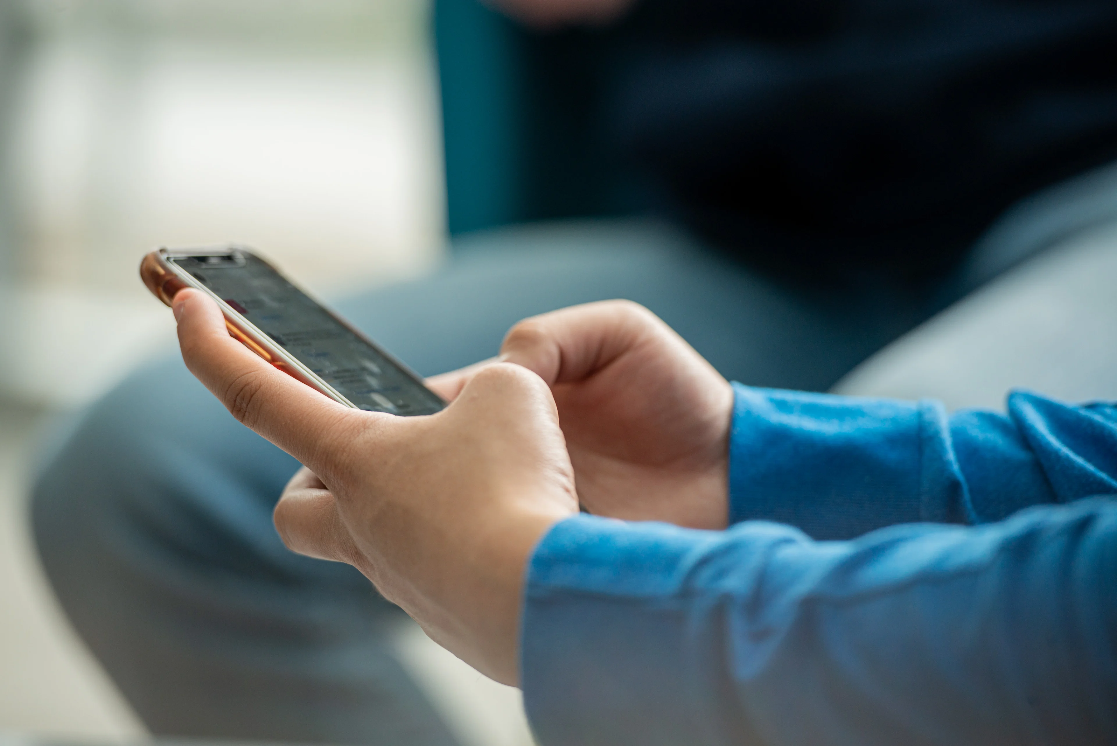 Student hands using a cell phone.