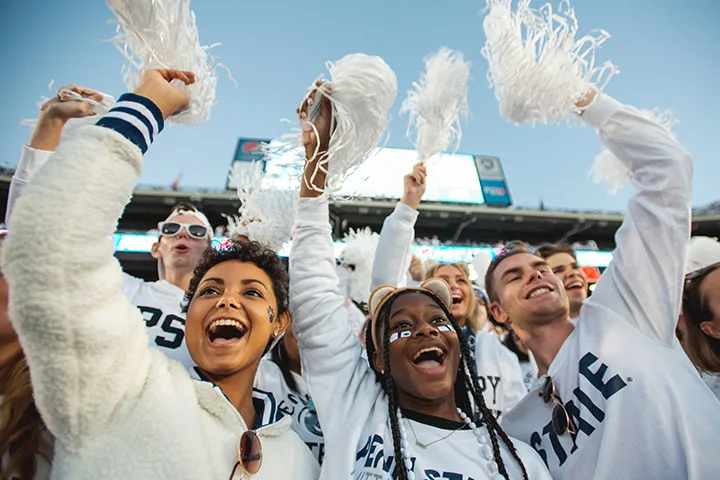 Photo of students cheering in the student section during a white out football game