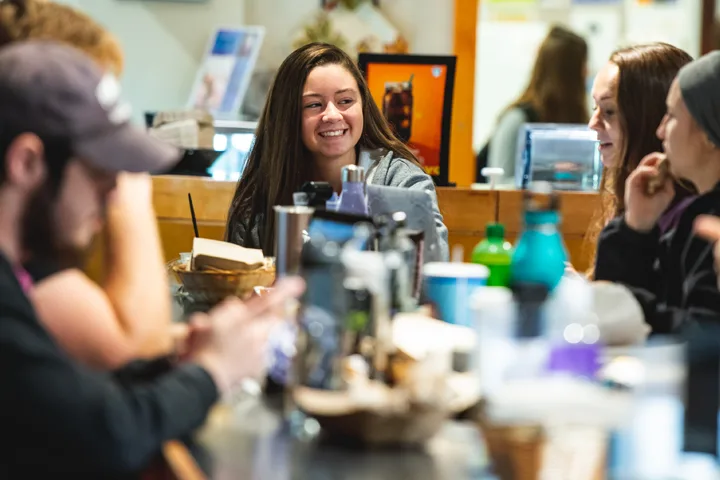 Student sitting at a table full of cups and food