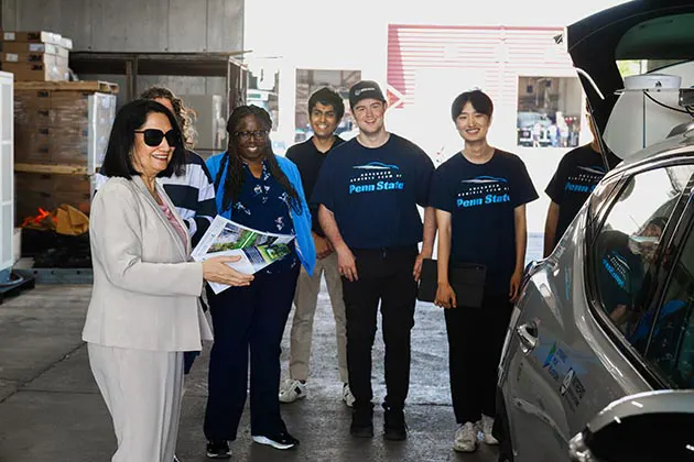 Neeli Bendapudi and six students observing a car