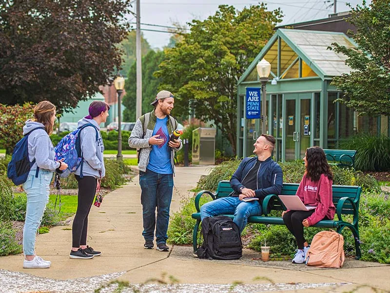 Two five talking outside on campus at Penn State Shenango.