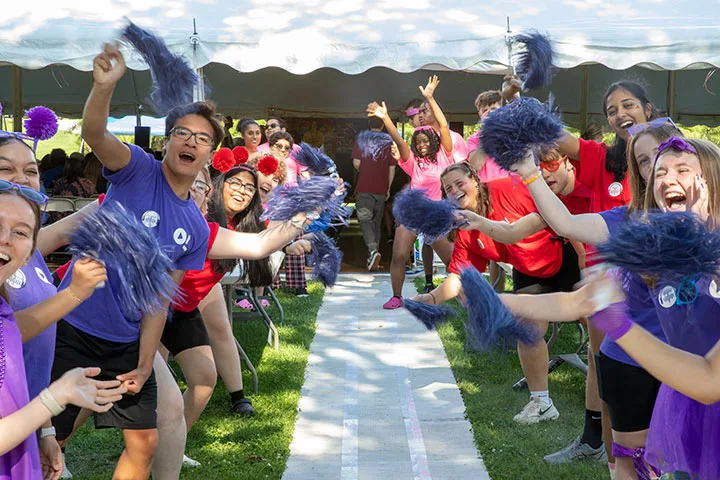 Photo of students waving pom-poms at an event