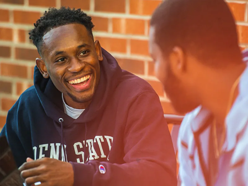 Photo of two students sitting and talking