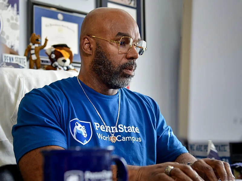 Person working at computer with World Campus t-shirt