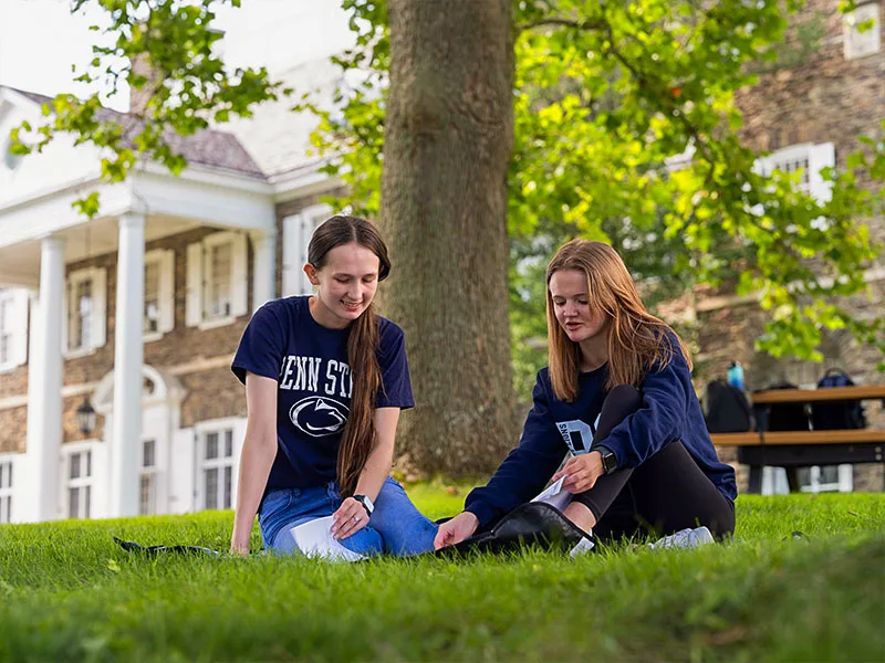 Two people studying in the grass at Penn State Wilkes Barre.