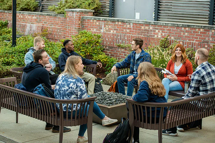 Photo of students sitting and talking in outdoor space
