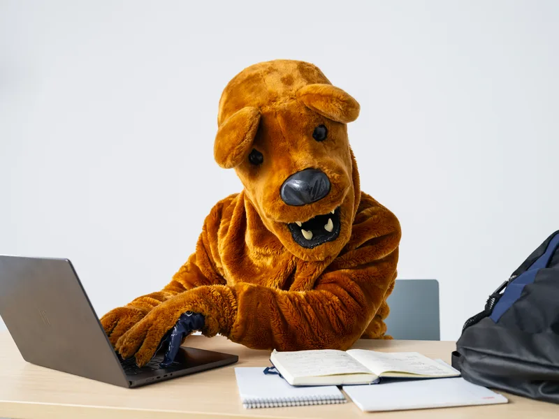 Nittany Lion working on a laptop.