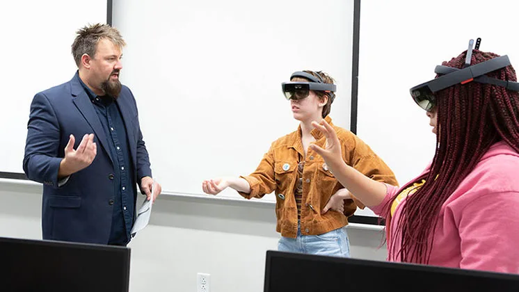 Photo of psychology students wearing VR headsets in a lab with a professor