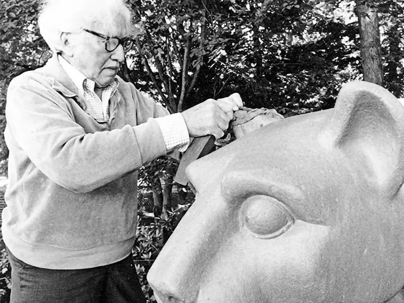 A black and white photo of the shrine’s sculptor, Heinz Warneke, repairing the Lion's ear.