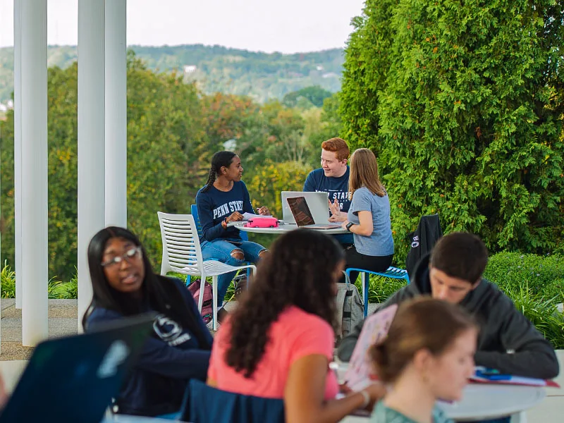 Students talking at outdoor tables at Penn State Beaver.