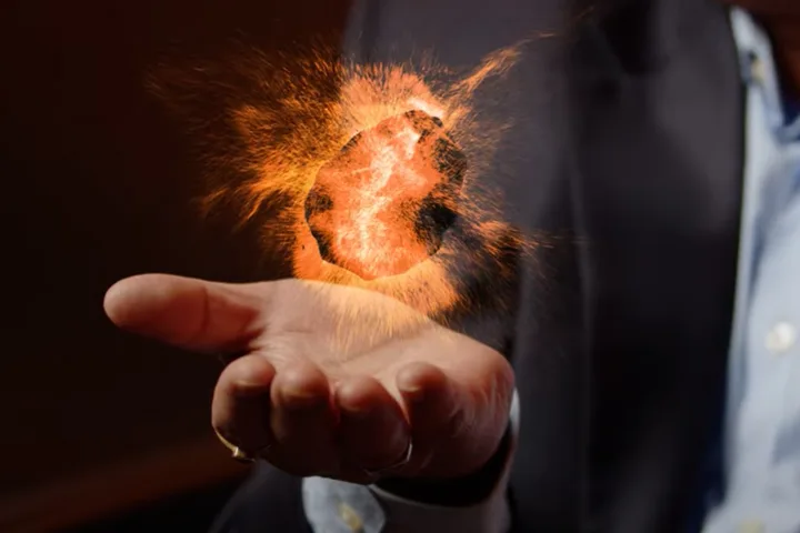 A rendering of a piece of coal floating above a researcher's hand