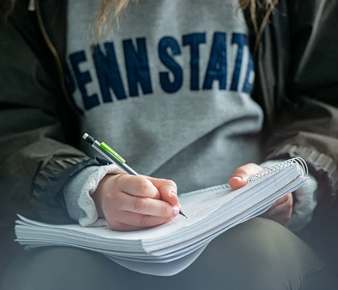 Close-up photo of a student writing in a notebook