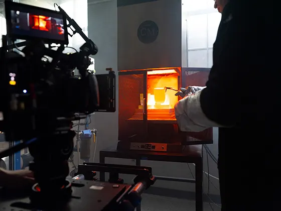 A researcher working on molten glass