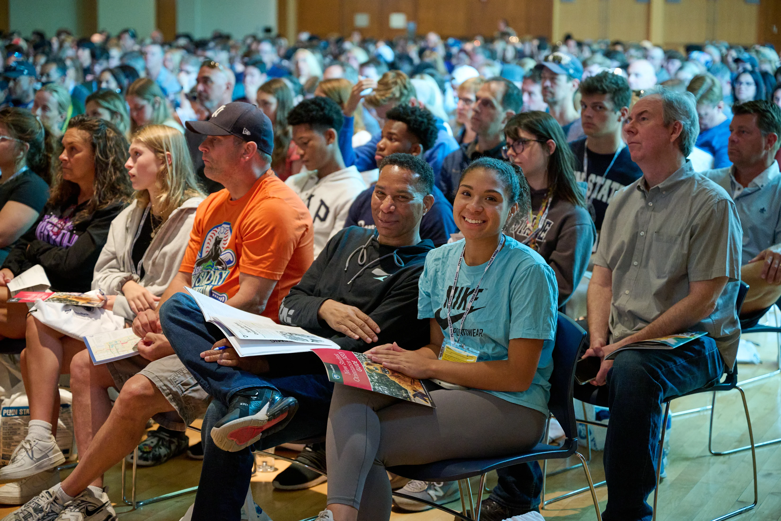 Large group of students and families seated inside auditorium