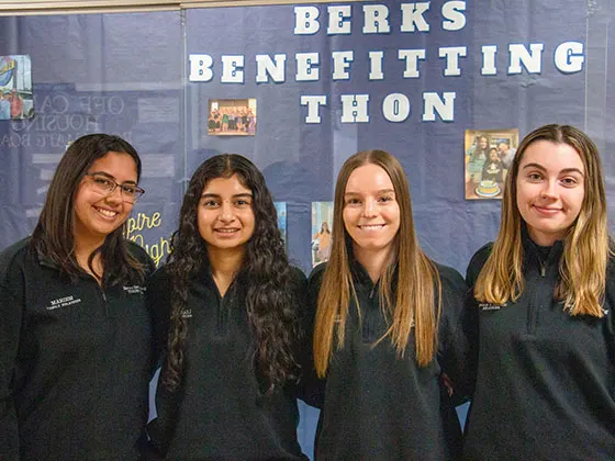 Photo of students smiling in front of a THON banner