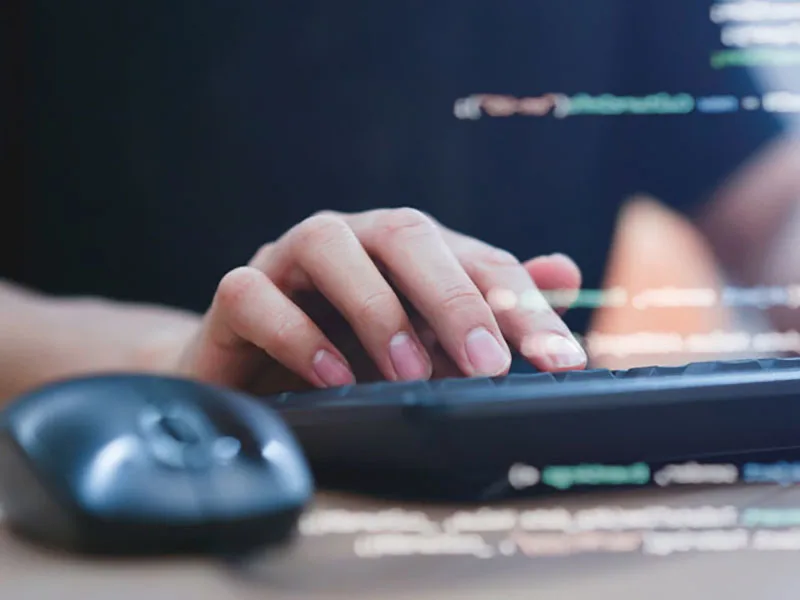 Close up of hand typing on keyboard and computer mouse